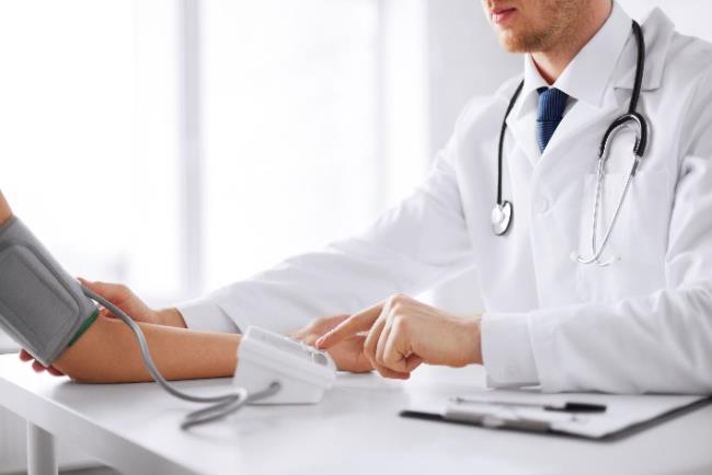 רופא מודד לחץ דם למטופל חולה לב כדי לבצע אופטימיזציה של הטיפול